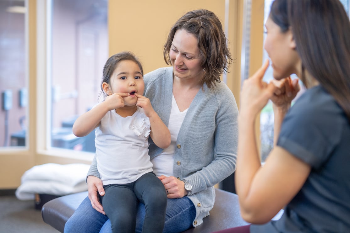 Speech therapist works with a kindergarten-age ethnic girl